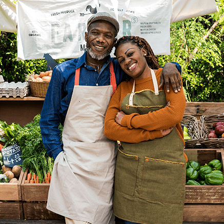 man and woman standing in front of produce