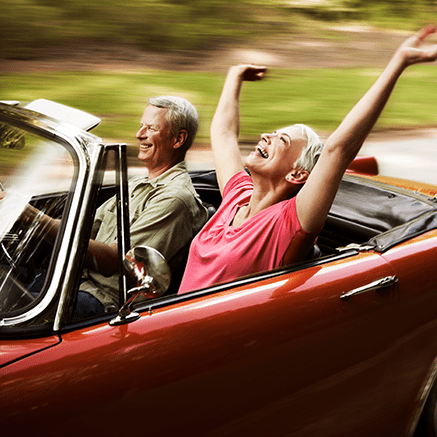 Features couple driving in convertible car