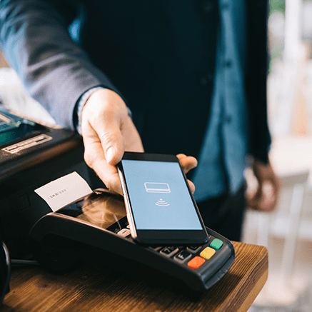 man paying at register with mobile phone