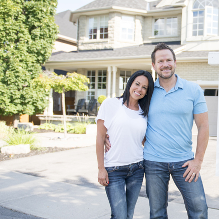 Jumbo Mortgages couple standing in front of new house
