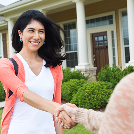 The Right Loan for You woman shaking hands with real estate agent outside of new home