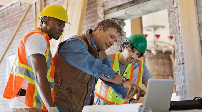 construction workers looking at blueprints