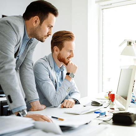 two business men looking at computer monitor