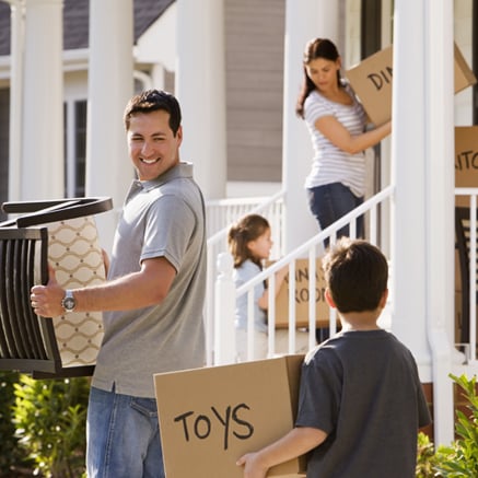Buying a Home Family carrying boxes into new home.