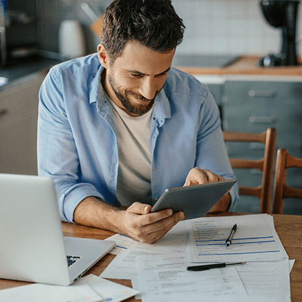 Bill Pay Benefits man working at desk with papers and computer