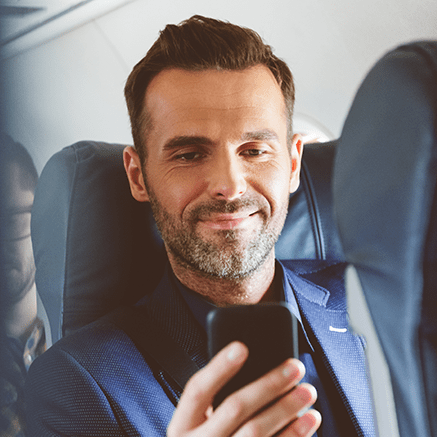 man on plane using cell phone