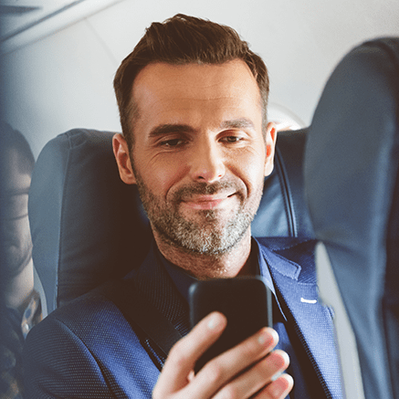 The Basics man on plane using cell phone