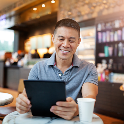 Man in coffee shop looking at tablet