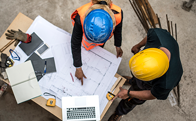 construction workers looking at blueprints